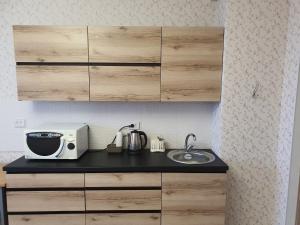 encimera de cocina con fregadero y microondas en 2-ух комнатная квартира Юнис Сити г.Актобе, en Aktobe