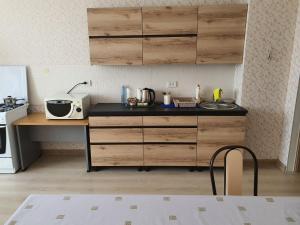 a kitchen with wooden cabinets and a counter top at 2-ух комнатная квартира Юнис Сити г.Актобе in Aktobe