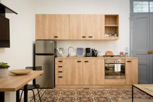a kitchen with wooden cabinets and a stainless steel refrigerator at Hidden Gem 1BR Apartment in Beirut