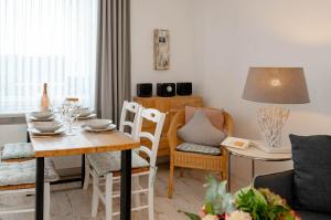 a living room with a table and chairs and a dining room at Heike in Westerland (Sylt)