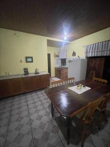 Il comprend une cuisine et une salle à manger avec une table et des chaises en bois. dans l'établissement Casa Família Mattos, à Xangri-lá