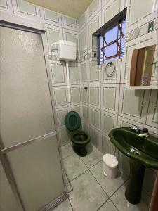 ein Badezimmer mit grünem WC und Waschbecken in der Unterkunft Casa Família Mattos in Xangri-lá + 5 Fotos