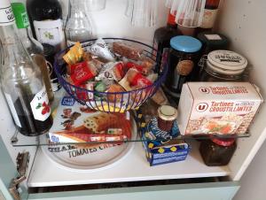 een koelkast gevuld met voedsel en andere voedingsmiddelen bij Chambre esprit 'plage' dans longère chez Stéphanie près circuit Mans in Marigné-Laillé