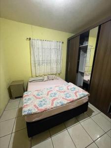 ein Schlafzimmer mit einem Bett in einem Zimmer mit einem Fenster in der Unterkunft Casa Família Mattos in Xangri-lá