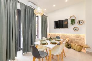 Un comedor con una mesa y sillas blancas. en Apartamento con piscina y terraza, en Valencia