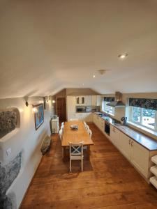 a large kitchen with a wooden table and a dining room at Ty Gwennol near Gilfach Goch in Llanbedr