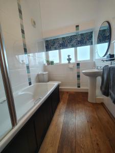 a bathroom with a large tub and a sink at Ty Gwennol near Gilfach Goch in Llanbedr