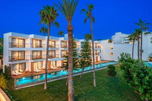 an apartment building with a swimming pool and palm trees at Yalihan Aspendos in Alanya