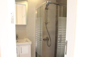 ein Bad mit einer Dusche und einem Waschbecken in der Unterkunft Modern 3 Bed 3 Bath Apt w Sea View in Beirut