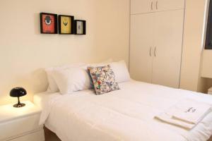 a white bed with a pillow on top of it at Modern 3 Bed 3 Bath Apt w Sea View in Beirut