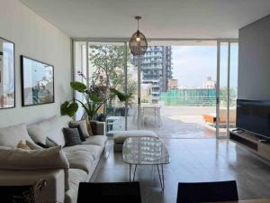 uma sala de estar com um sofá e uma mesa em Dreamy 3BR Penthouse w a Super Terrace em Beirute