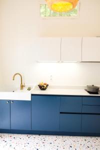 a kitchen with blue cabinets and a sink at MaïHomes - La Villa Marseillaise in Marseille