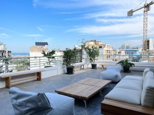 um pátio com sofás e uma mesa no telhado em Dreamy 3BR Penthouse w a Super Terrace em Beirute
