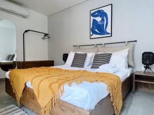um quarto com uma cama grande com um cobertor amarelo em Dreamy 3BR Penthouse w a Super Terrace em Beirute