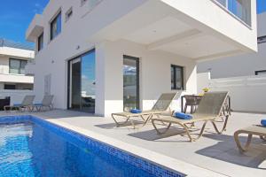 une villa avec piscine et mobilier de jardin dans l'établissement Villa Genesis, à Protaras