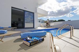 a house with a swimming pool and a book on a table at Villa Genesis in Protaras