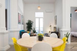 a dining room with a table and yellow chairs at Little Urban Palace 4BR Beirut in Beirut