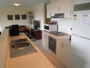 a small kitchen with a sink and a microwave at The Haven - Island Beach in Island Beach