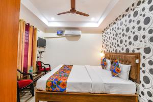 a bedroom with a bed and a ceiling fan at FabHotel Sagar Royale in Bhubaneshwar