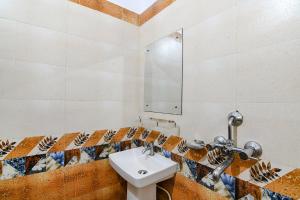 uma casa de banho com um lavatório e um espelho em FabHotel Sagar Royale em Bhubaneshwar
