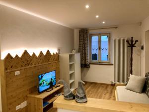 a living room with a wooden wall with a flat screen tv at Casa Volcan in Tesero