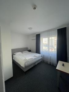 1 dormitorio con cama blanca y ventana en Hotel Ada - Otoka en Sarajevo