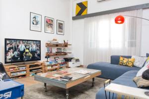 a living room with a blue couch and a tv at Bright Architect Home in Badawi With Rooftop in Beirut