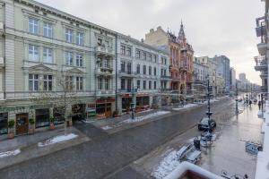 a city street with buildings and snow on the ground at Beautiful Studios Piotrkowska by Renters in Łódź