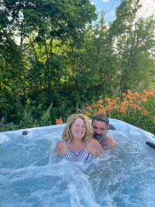 un hombre y una mujer en un jacuzzi en Auberge musicale Pour un Instant en La Malbaie