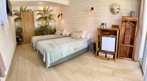 1 dormitorio con 2 camas y TV de pantalla plana en La Case O zoizos en Saint-Joseph