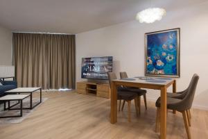 a living room with a table and a tv at Apartament Premium PINEA 203 in Pobierowo