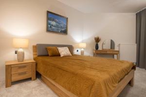 een slaapkamer met een groot bed en 2 nachtkastjes bij Apartament Premium PINEA 203 in Pobierowo