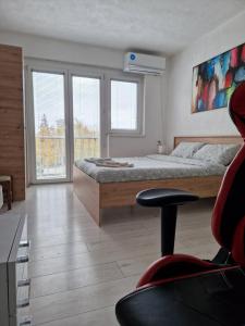 a bedroom with a bed and a desk and a chair at City Square Apartment in Kumanovo