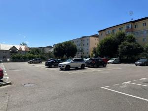 a parking lot with several cars parked in it at Page2 Apartament in Târgovişte