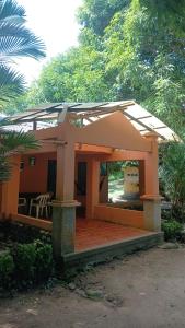 a pavilion with a roof on top of a house at Hospedaje Eden in Los Naranjos