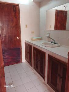 a bathroom with a sink and a mirror at Hospedaje Eden in Los Naranjos