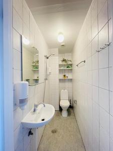 a white bathroom with a sink and a toilet at aday - Sunset Suite in Randers
