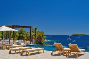 a patio with chairs and a pool with a view of the ocean at Immensely Luxurious Hvar Villa - 5 Bedrooms - Villa East Eternal - Exceptional Sea Views and Private Pool in Hvar