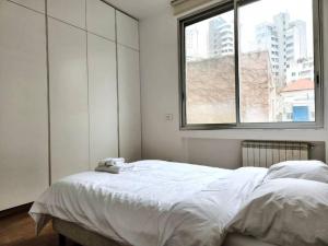 貝魯特的住宿－Chic Contemporary 3BR in Mar Mikhael，白色的卧室设有一张大床和一个窗户