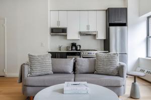 a living room with a couch and a kitchen at Hudson Yards 1br w gym wd nr penn station NYC-1308 in New York