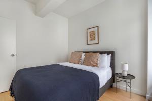 a bedroom with a bed with a blue blanket at Hudson Yards 1br w gym wd nr penn station NYC-1308 in New York