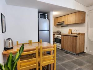 a kitchen with a wooden table and a stainless steel refrigerator at Railway House 2BR Apt w front yard in Beirut