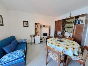 uma sala de estar com uma mesa e um sofá azul em La vista più bella em Castelsardo