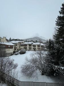 un patio cubierto de nieve con una valla en Gina's Home - Appartamento nel cuore di Bardonecchia en Bardonecchia