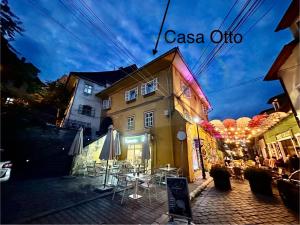 a building with tables and umbrellas on a street at Casa Otto Sighisoara in Sighişoara