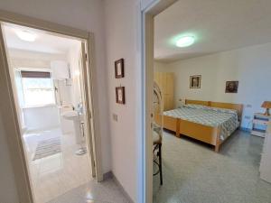 um quarto com um quarto com uma cama e uma casa de banho em La vista più bella em Castelsardo