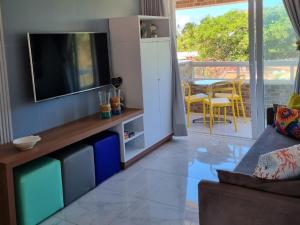 un salon avec une télévision sur un mur dans l'établissement Makaiba Residence 203, à Porto de Galinhas