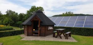 ein kleines Haus mit einem Tisch und Sonnenkollektoren in der Unterkunft Camping Officiel Wollefsschlucht Echternach in Echternach + 3 Fotos