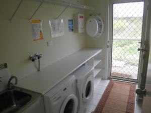 uma cozinha com um lavatório e uma máquina de lavar roupa em The Haven - Island Beach em Island Beach