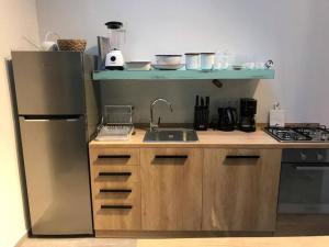 a small kitchen with a sink and a refrigerator at Skylight 1BR Apartment Mar Mikhael in Beirut